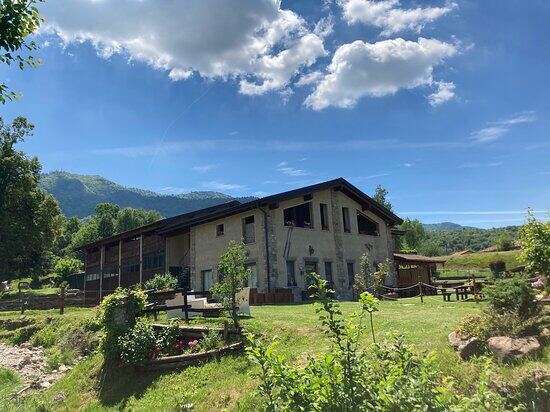 Il casale dell'Agriturismo Terra Piccinelli immerso nel verde, con le montagne sullo sfondo